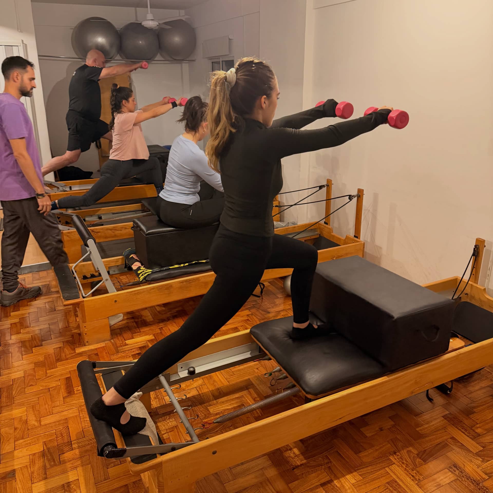 Clase guiada en Reformer, con atención cercana en el estudio