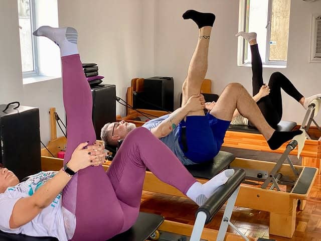 Estiramiento en Reformer durante una clase en el estudio